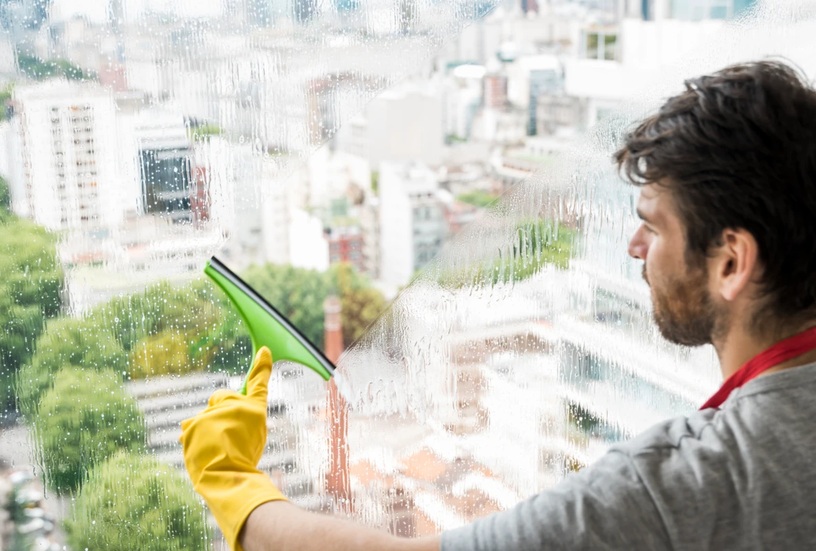 A window cleaner working glass at an occupied residential building